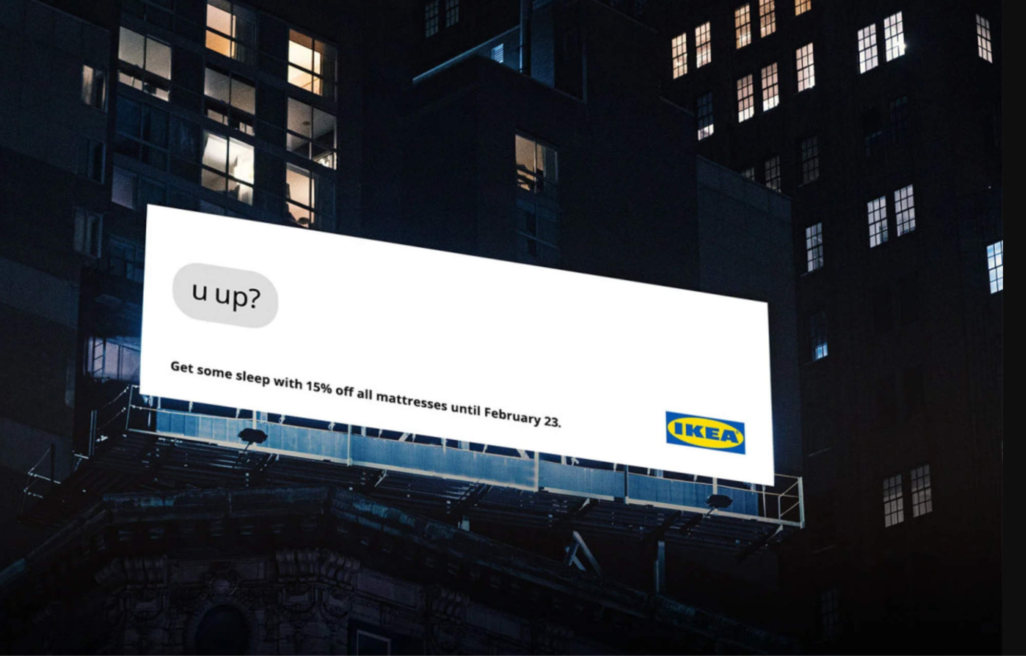 A billboard against building featuring a phone with a text from Ikea that says "u up?"
